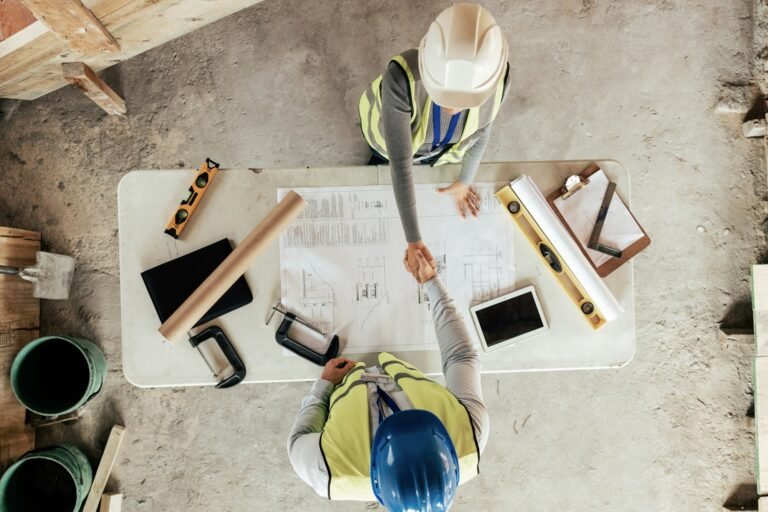 Architect, handshake and thank you for construction, blueprint and collaboration on building design