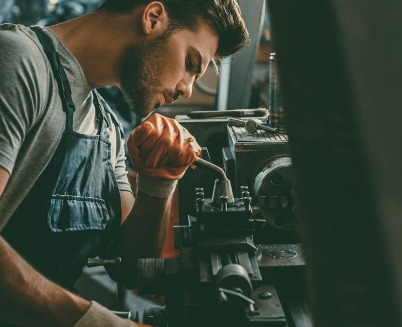young handsome professional repairman working in workshop